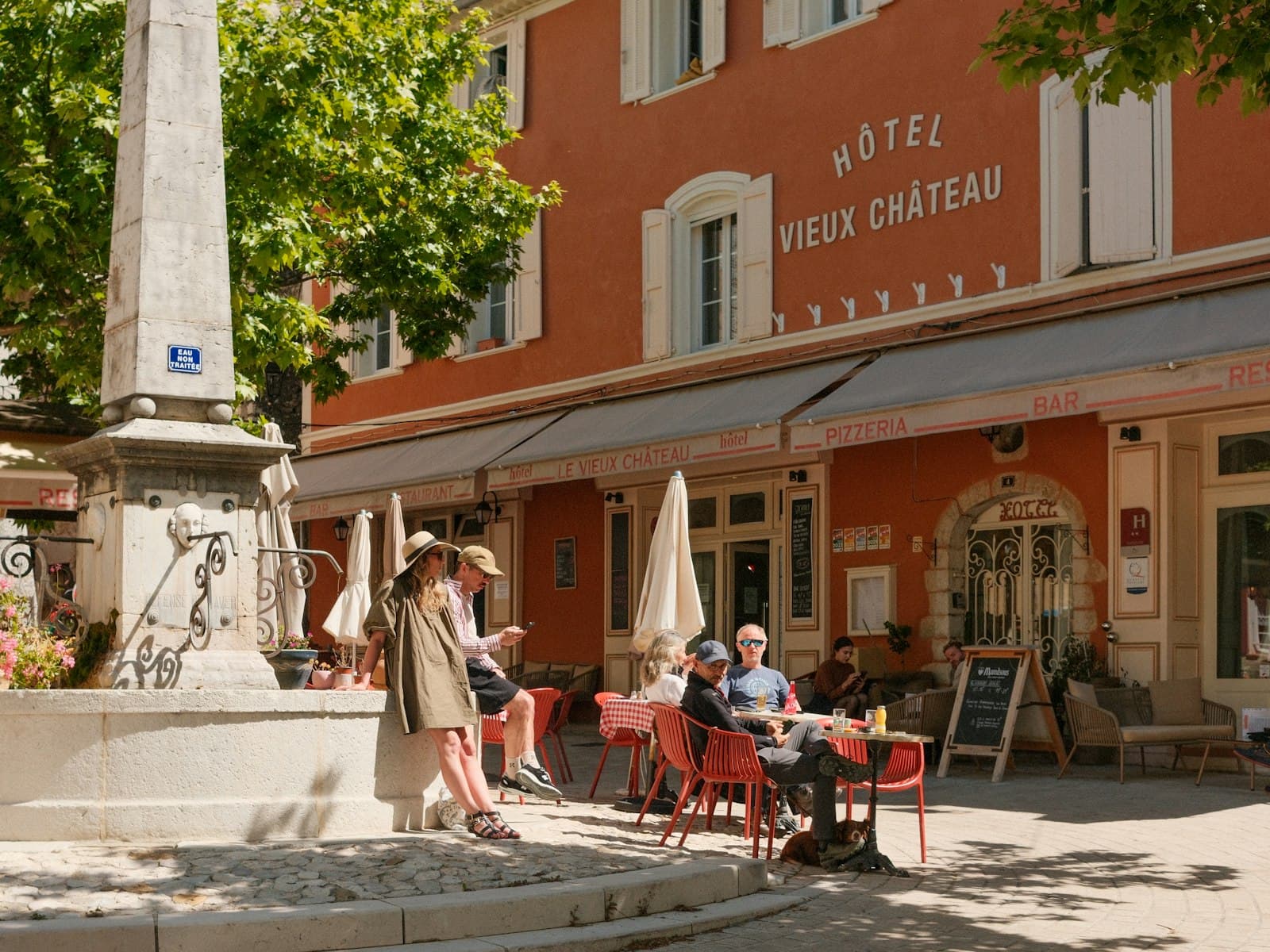 Une place de village française avec sa terrasse de café et sa fontaine